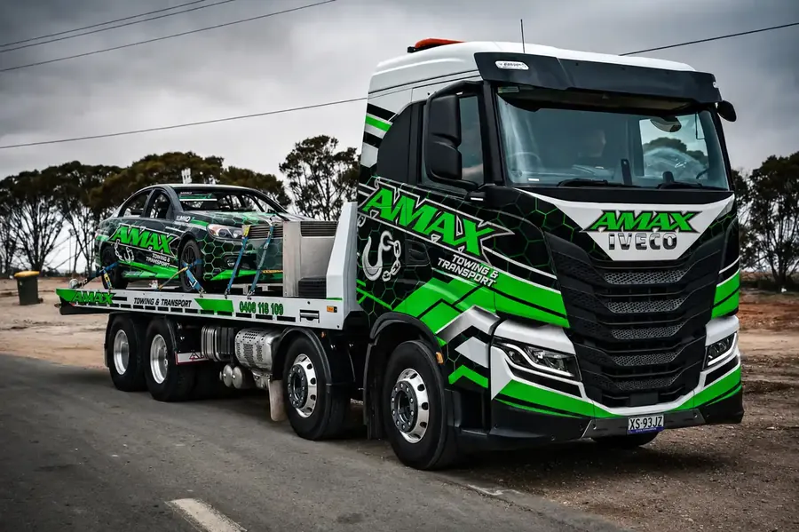 AMAX branded IVECO tow truck carrying an AMAX race car in regional South Australia